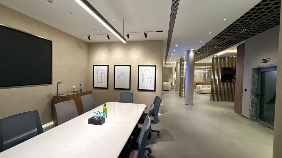 Meeting room & gallery. A meeting table with framed sketches, looking out towards the lounge.
